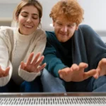 Castle eco solutions medium shot couple warming up with heater [city]