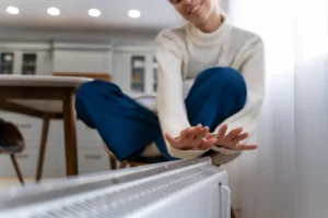 Castle eco solutions smiley woman sitting near heater home Blackburn